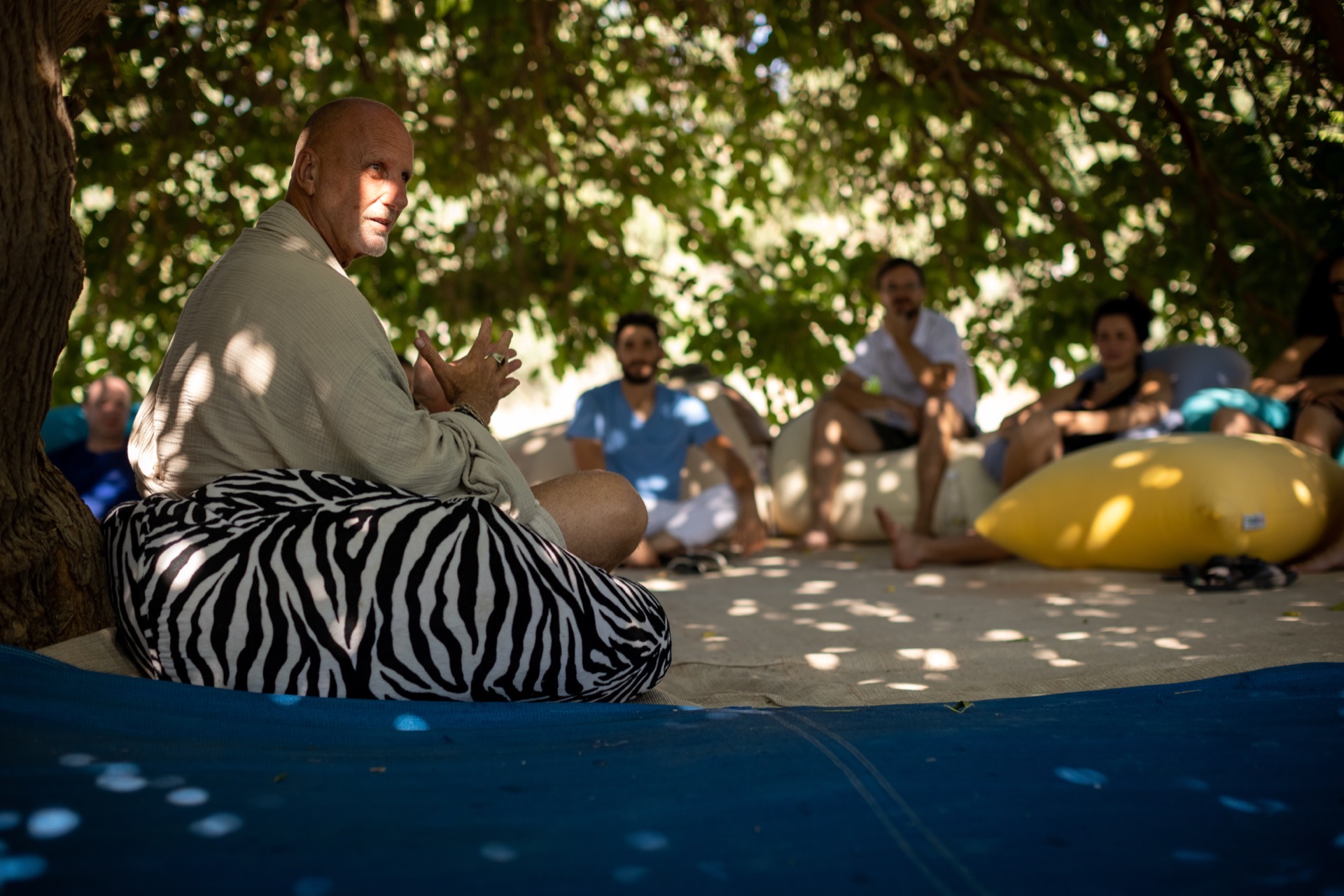 Yossi leading a circle under the tree